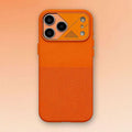 Bright orange smartphone case with metallic camera guard and textured bottom panel.